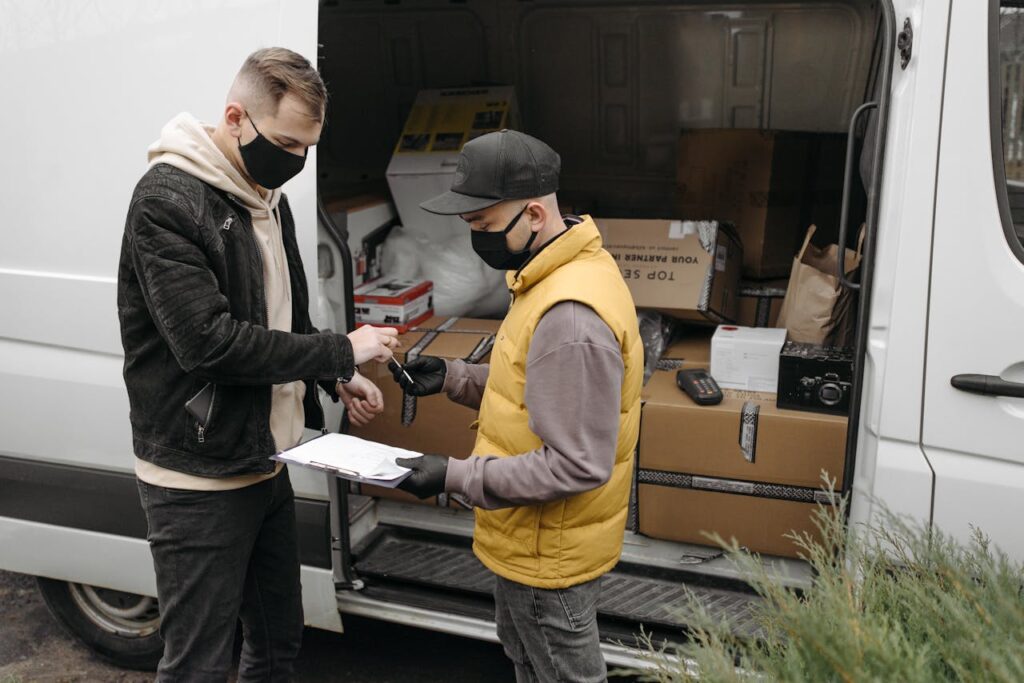 photo 6407584 Courier wearing face mask delivers packages to a customer maintaining safety protocols.